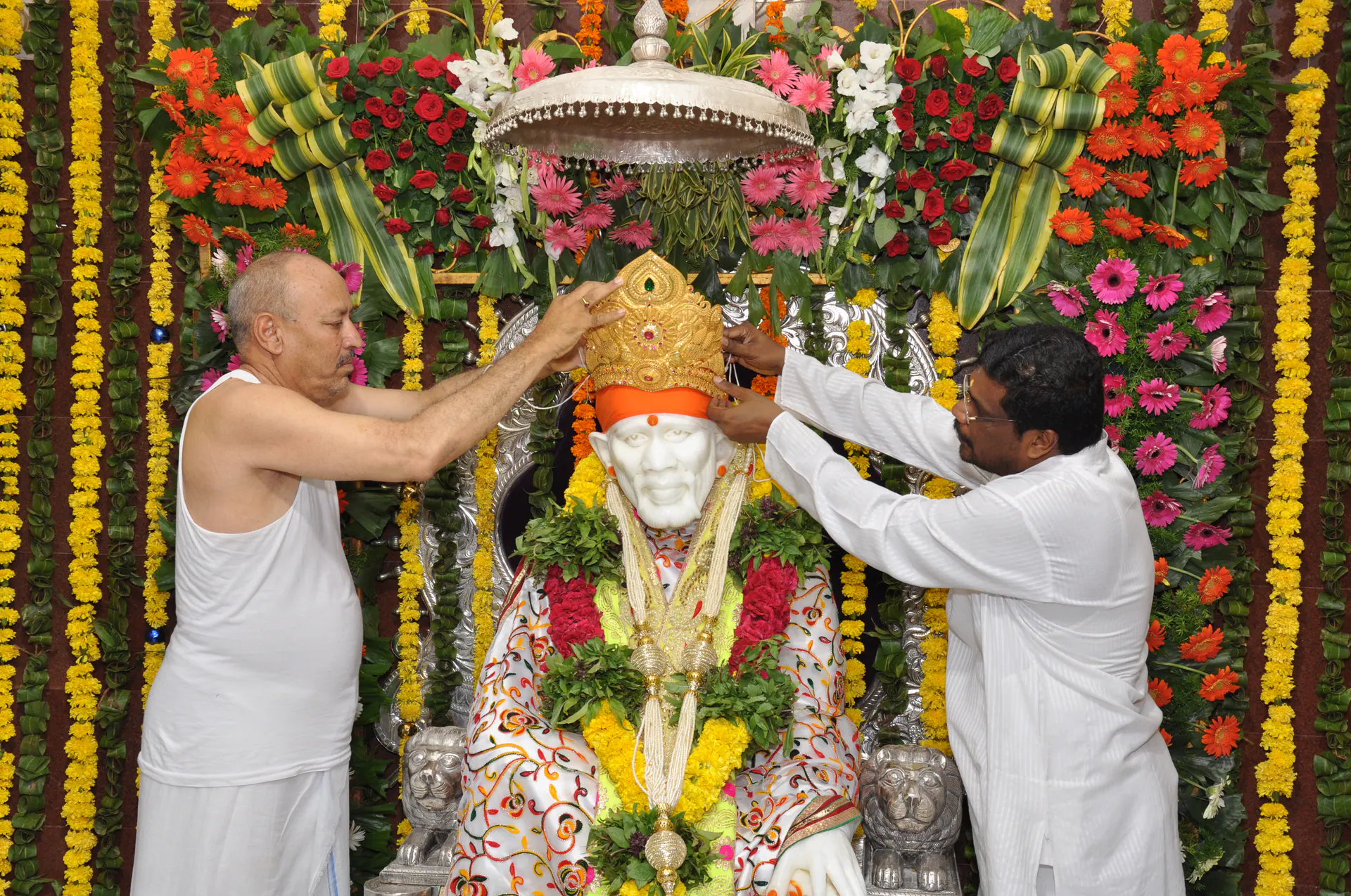 Devotees offering aarti to Sai Baba murti during a temple celebration