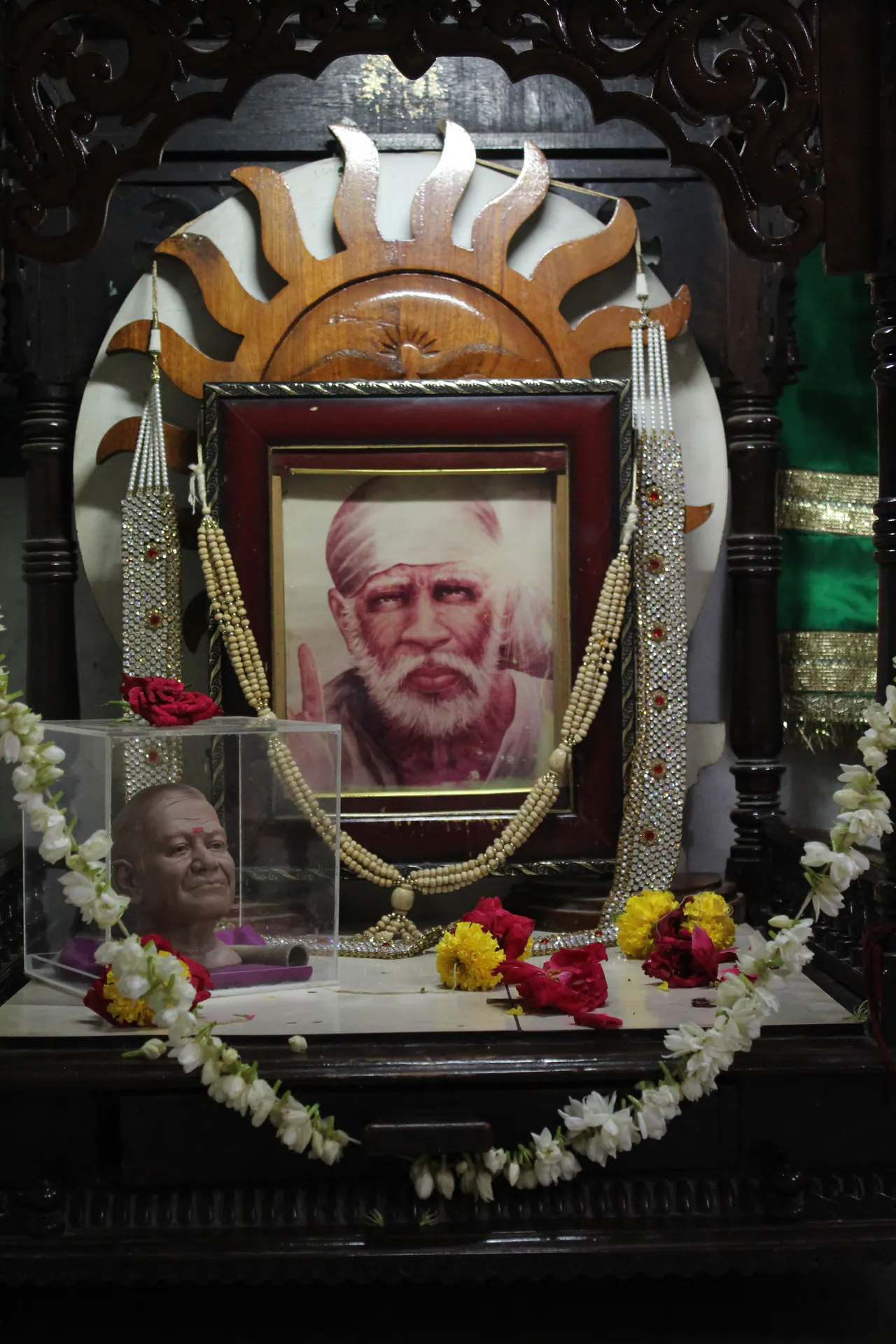 Framed devotional photographs and flowers inside Gurusthan
